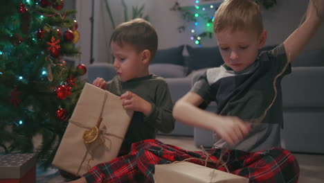 Zwei-Jungen-Packen-Weihnachtsgeschenke-Unter-Einem-Weihnachtsbaum-Aus.-Kinder-öffnen-Geschenke.-Hochwertiges-4K-Filmmaterial
